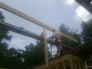 Carpenter setting a ridge beam over a new addition frame — Ice Dam Removal by Roofing Brothers in Warfield