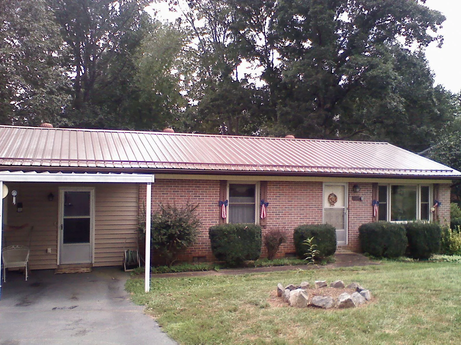 Bronze metal roof and carport on a brick ranch home — Roof Repair work by our crew in Warfield